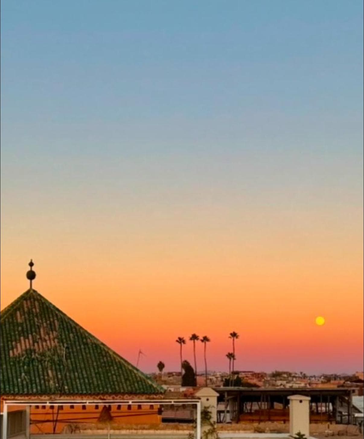 Sunset behind the green tiled rooftop