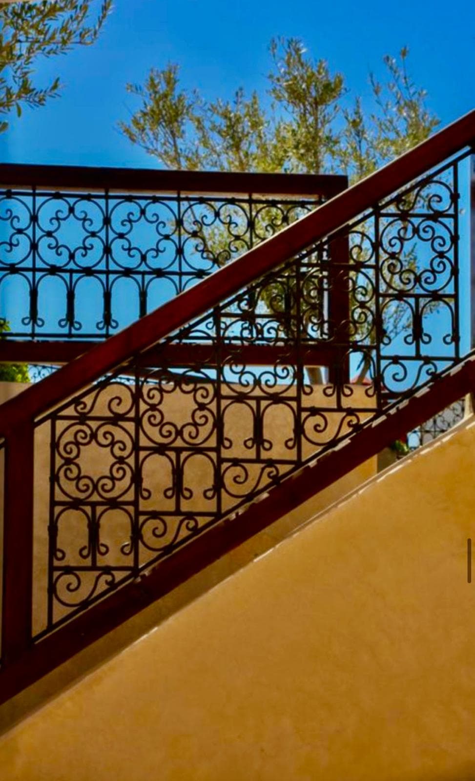 Wrought-iron staircase and olive tree