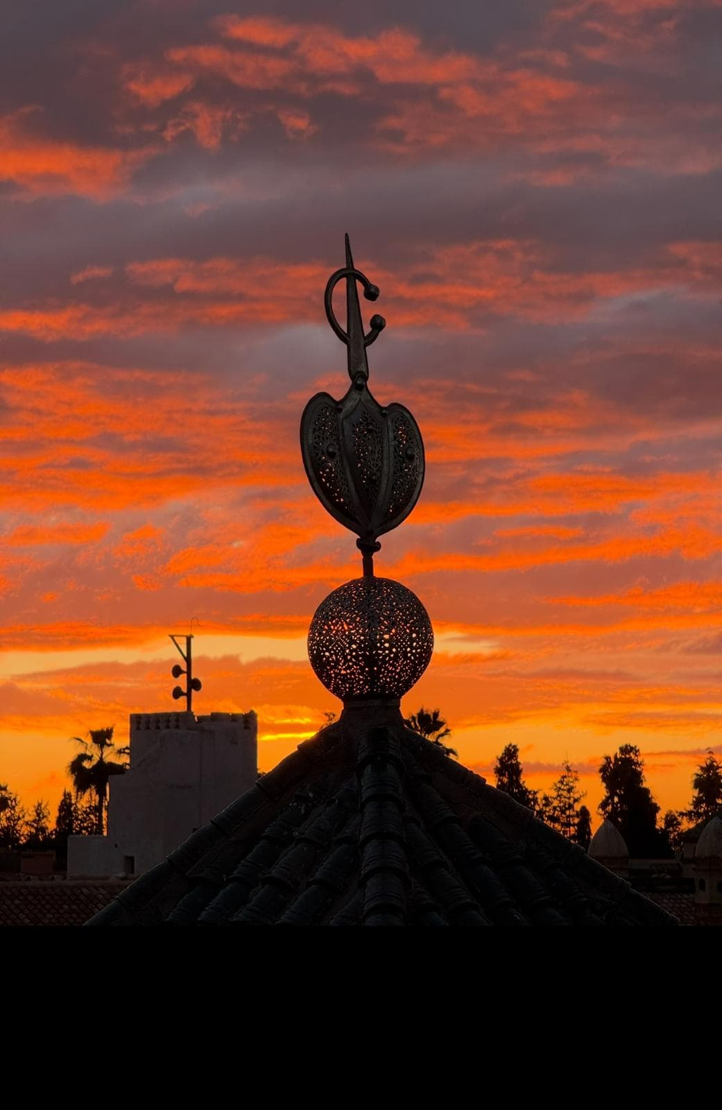 Marrakech sunset with ornate Moroccan finial silhouette