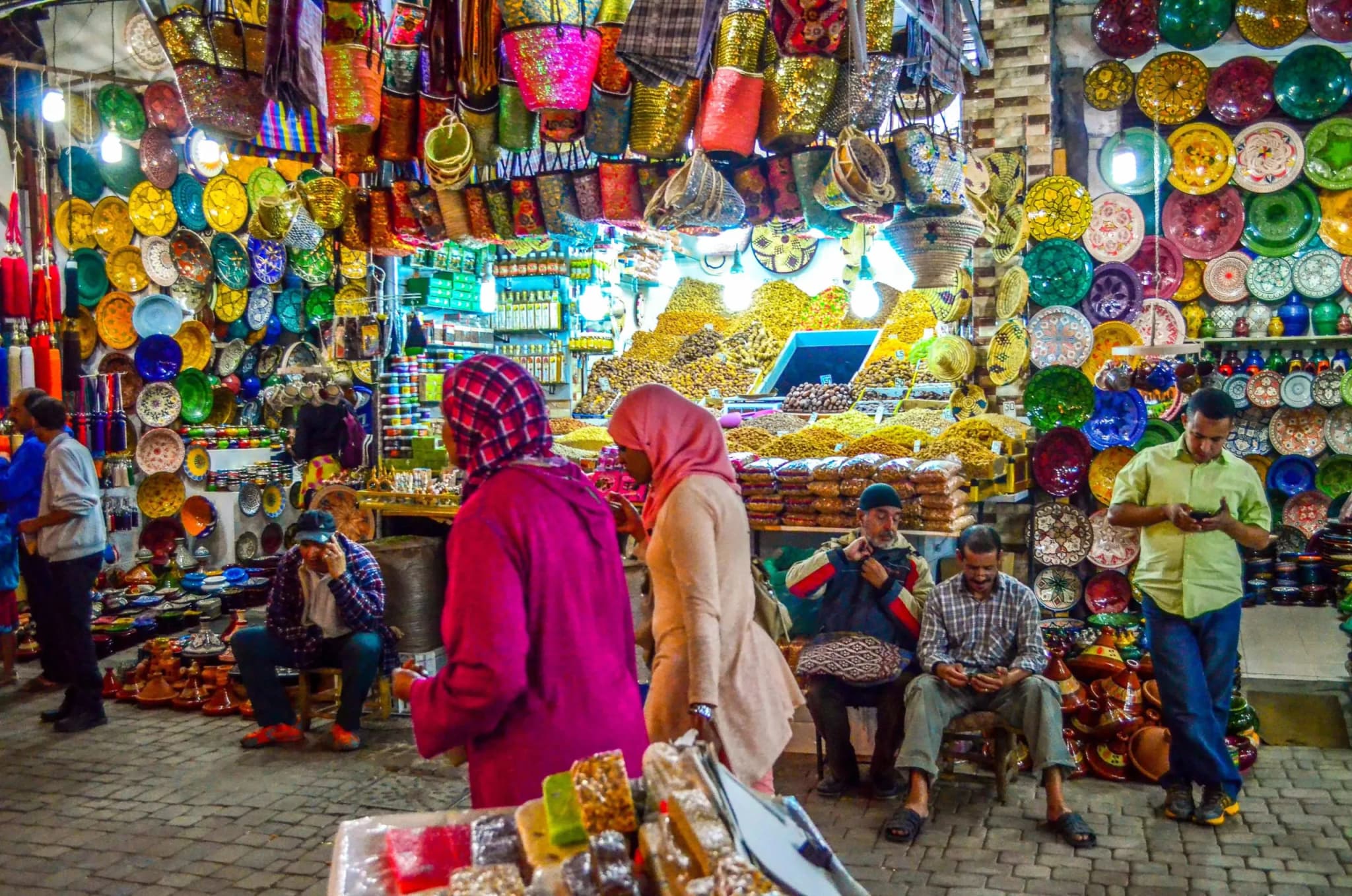 Vibrant Marrakech medina souk with hanging lanterns, leather goods and craftsmen