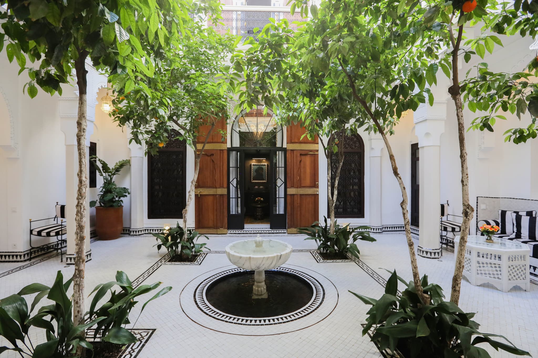 Sunlit courtyard of Riad Sa'eed with orange trees and marble fountain