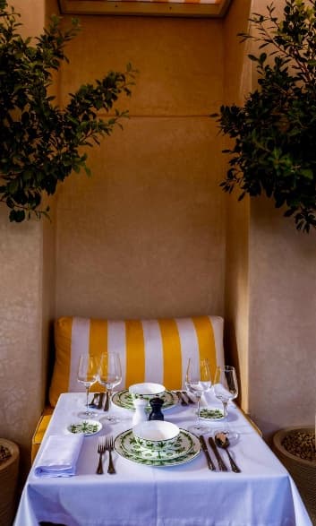 Intimate alcove table for two with greenery at Riad Sa'eed